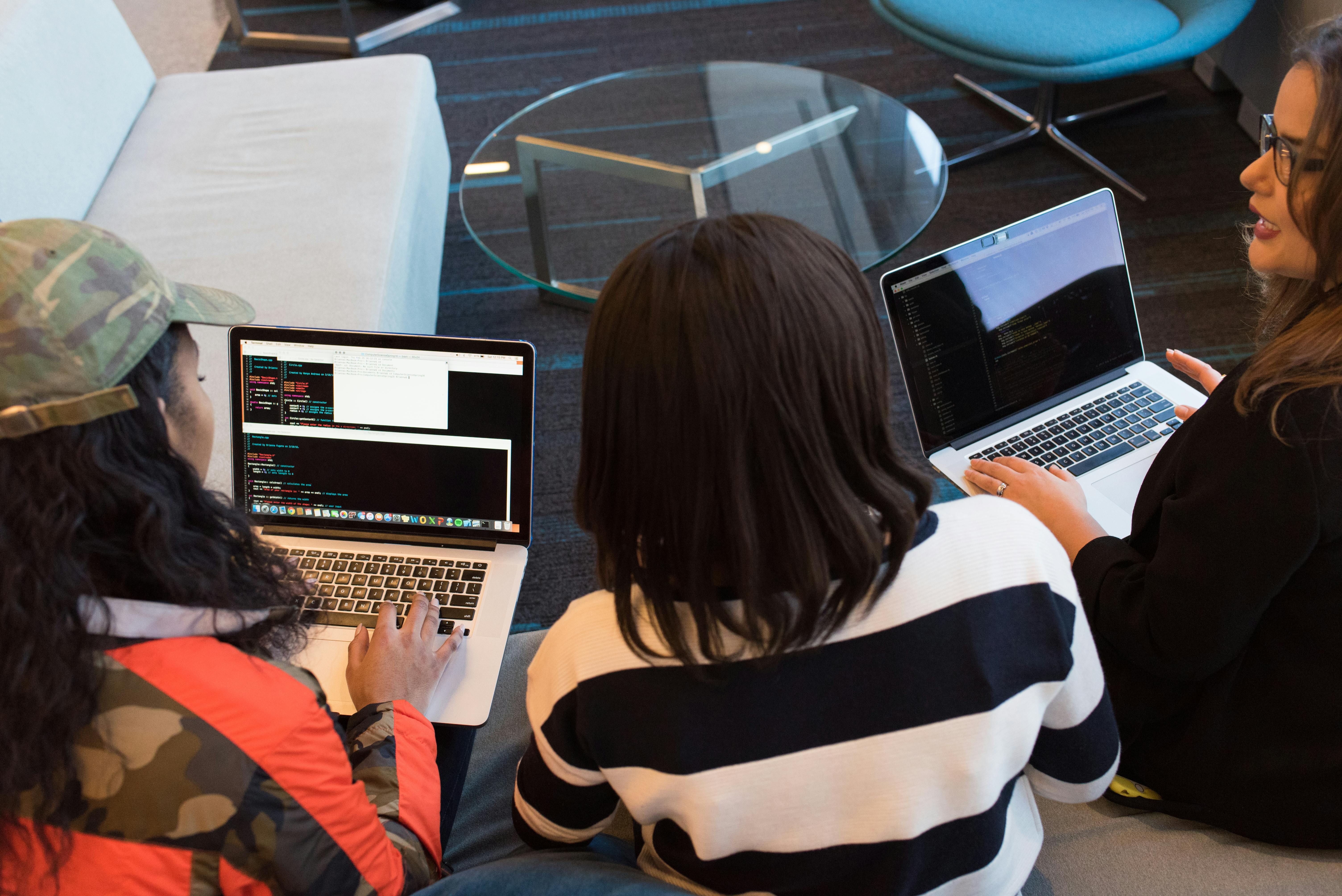 Students coding on laptops during collaborative hackathon event
